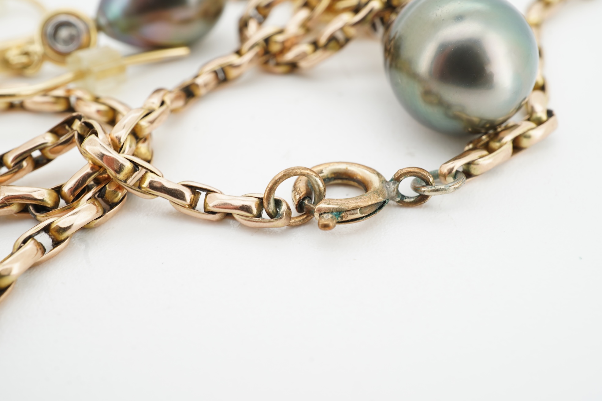 A cultured pearl and diamond demi-parure, comprising: a pendant, suspending a drop-shaped cultured pearl of black tint, measuring approximately 15 x 10.5 x 10.5mm, surmounted by a collet-set brilliant-cut diamond weighin